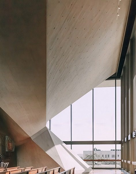 Intérieur d’un bâtiment en béton brut ouvert sur l’extérieur par de grandes baies